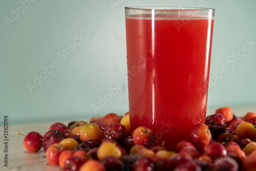 Wallpaper Mural Glass of acerola juice and fresh acerola fruits on a wooden surface Torontodigital.ca