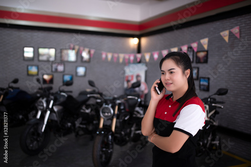 Fototapeta Naklejka Na Ścianę i Meble -  Professional female salesman at a motorcycle dealer in a sales showroom in Asia.