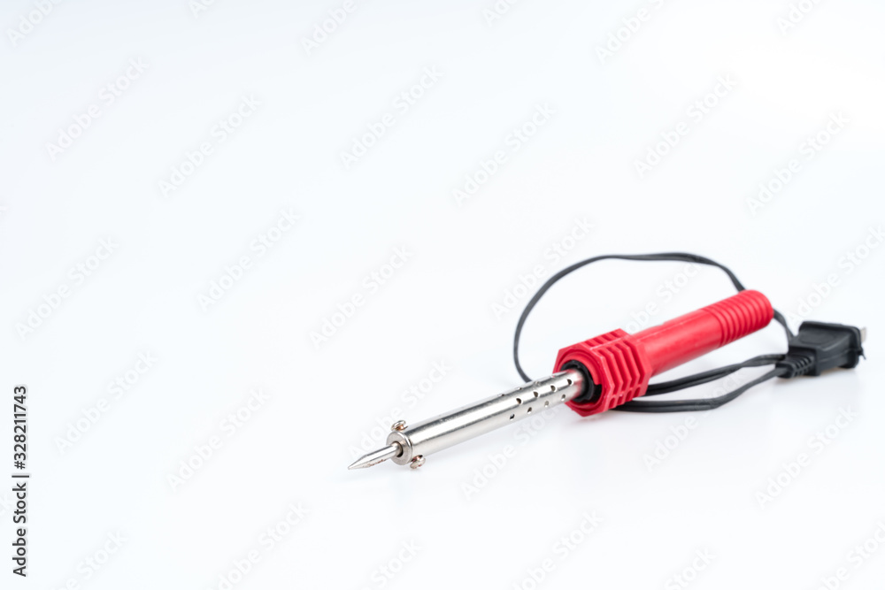 Soldering iron with a red handle for heating to melt solder Soldering iron with a red handle for heating to melt solder