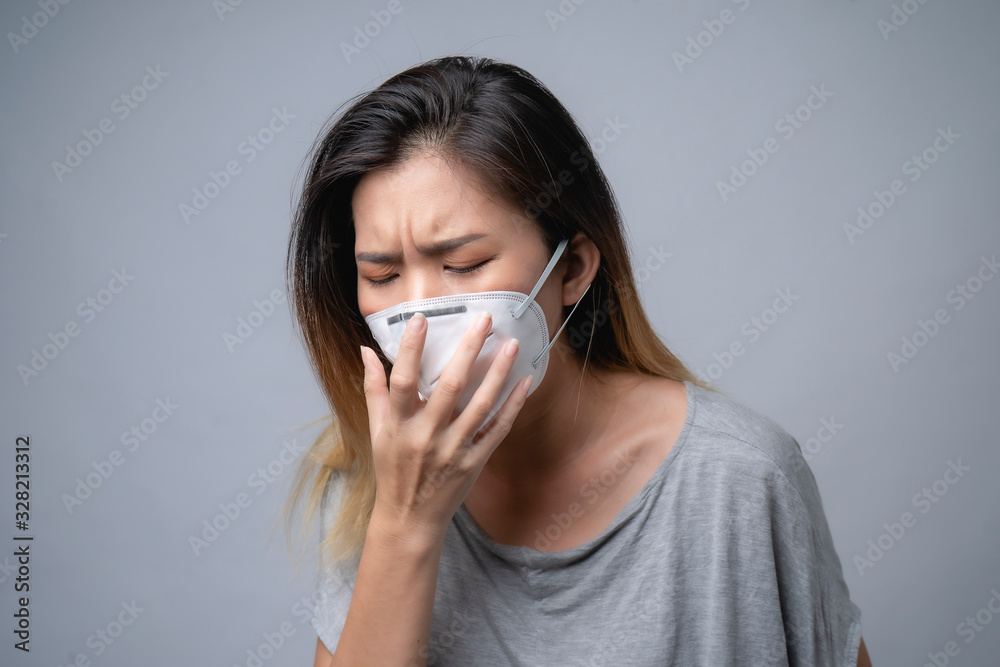 Young woman wearing surgical mask, studio shot Young woman wearing surgical mask, studio shot