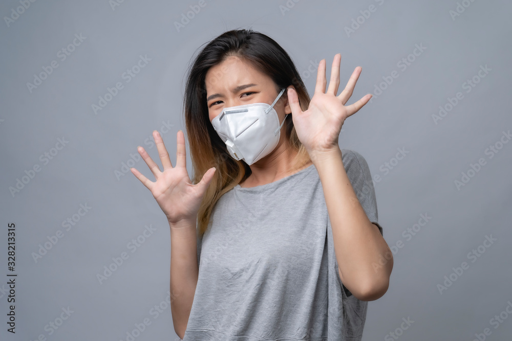 Young woman wearing surgical mask, studio shot Young woman wearing surgical mask, studio shot