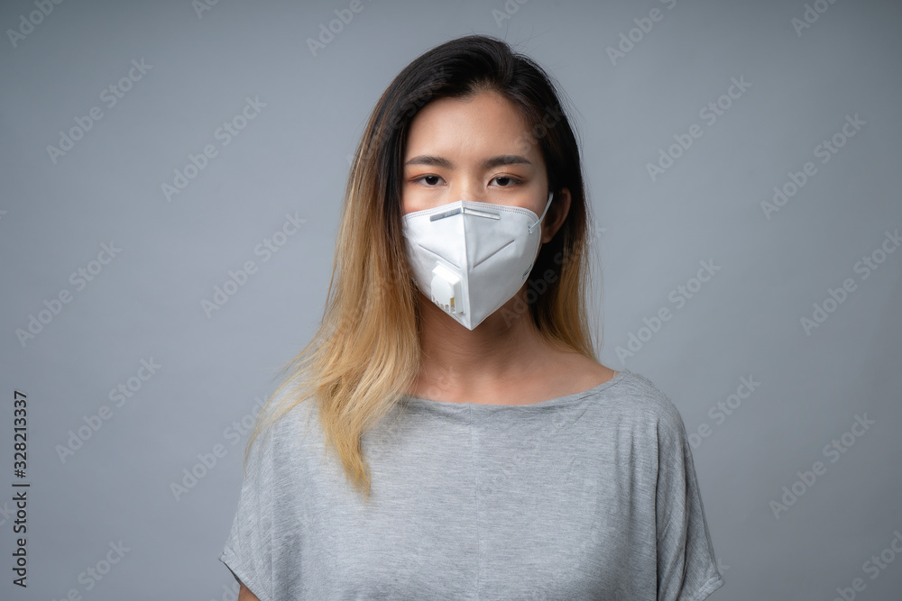 Young woman wearing surgical mask, studio shot Young woman wearing surgical mask, studio shot