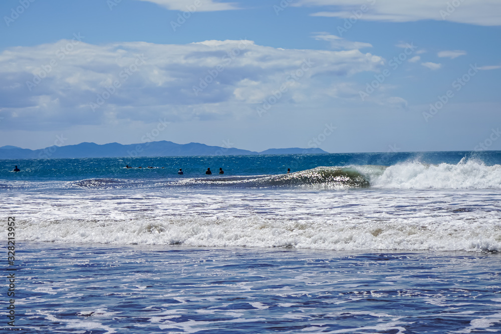 Beautiful aerial view of surfers surfing in Naranjo Beach 