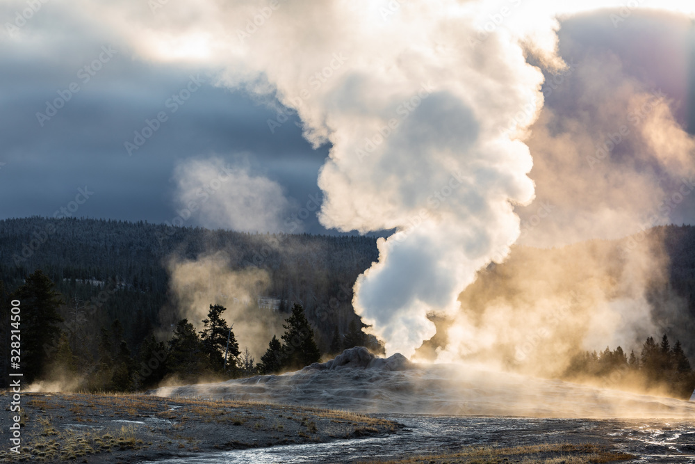 Fototapeta premium Old Faithful, Yellowstone exploding hot smoke before eruption in morning.