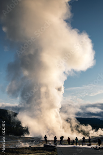 Old Faithful, Yellowstone exploding hot smoke before eruption in morning.