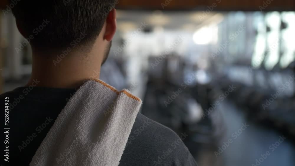 Confident Man Enters Gym and Throws Towel over Shoulder ready to succeed Confident Man Enters Gym and Throws Towel over Shoulder ready to succeed