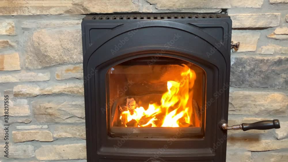 bright orange fire burns in a black fireplace, a cozy home concept bright orange fire burns in a black fireplace, a cozy home concept