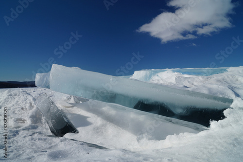 blue blocks of ice against a bright blue sky and white snow