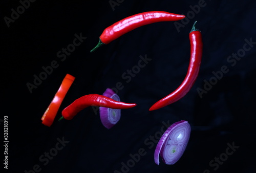 natural vegetable spices made from hot and sweet peppers and onions hung on a dark background