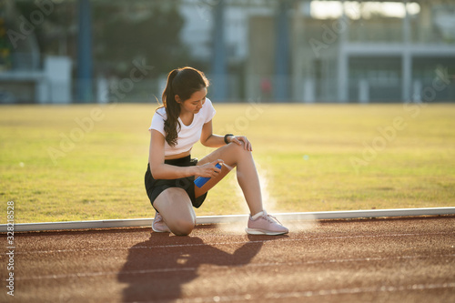 Foto Asian woman runners knee and calf injuries due to practice She uses spay to reduce injuries