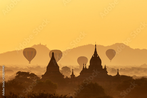 Scenic and stunning sunrise with many hot air balloons over Bagan in Myanmar. Bagan is an ancient city and World Heritage Site certified by UNESCO with thousands of historic buddhist temples