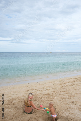 Beautiful portrait of mother and daughter on the sea and beach background.