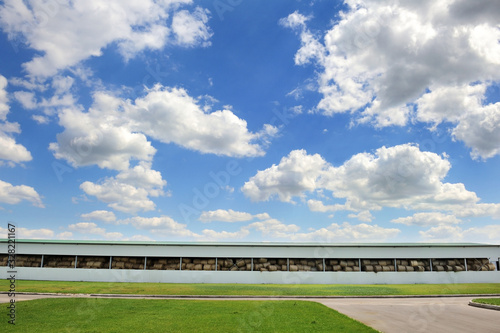 Canvas-taulu Large hangar for storing hay on green grass