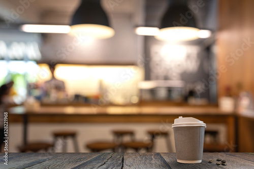 Fototapeta Wood table top with blur in coffee shop. with gray paper coffee mug.