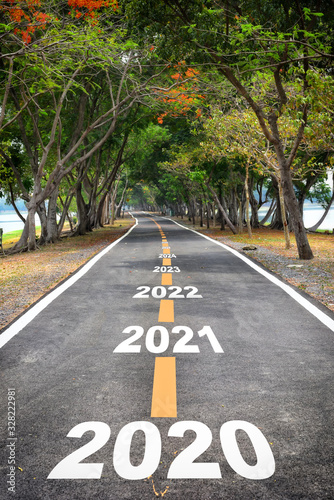 Tree tunnel with 2020 to 2026 on asphalt road surface, happy new year concept and natural idea