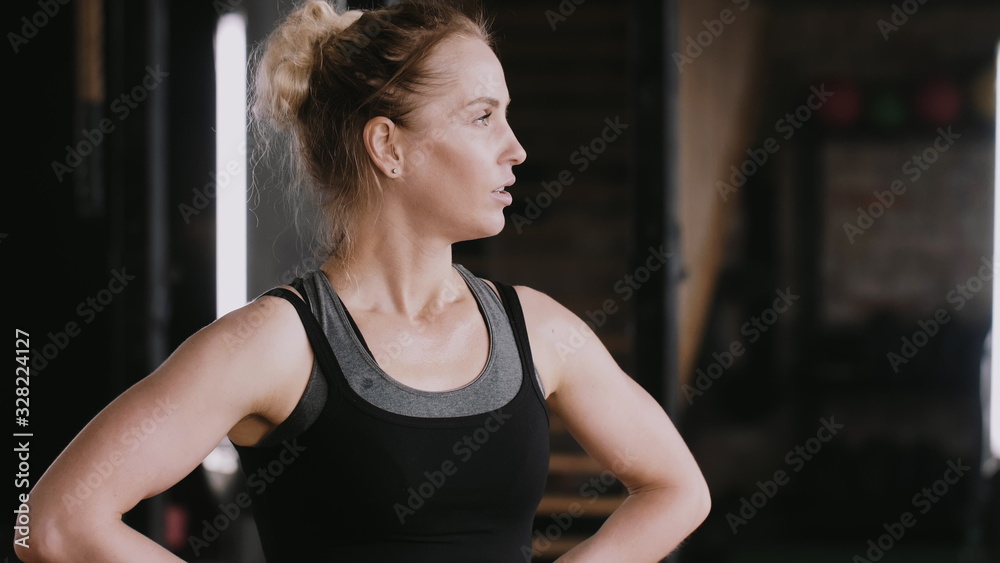Close-up young beautiful fit blonde woman tired and exhausted, heavy breathing after jump rope gym workout slow motion.