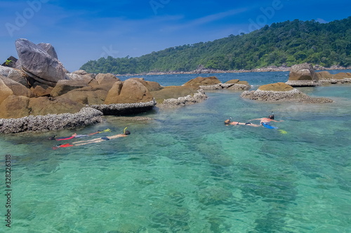 view of tourist snorkeling in blue-green sea around with many rocks background, Ko Jabang island, long-tail boat trip from Lipe island, Satun, southern Thailand.