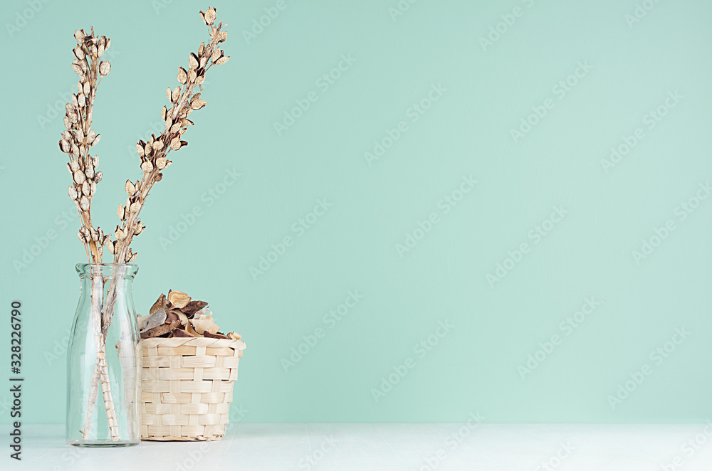 Home decorations in eco style - beige wooden wicker basket, dried plant and flowers, glass bottle in green mint menthe interior on white wood board. - obrazy, fototapety, plakaty 