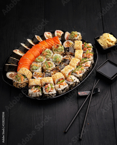 Traditional Japanese sushi food rolls on a black wooden background