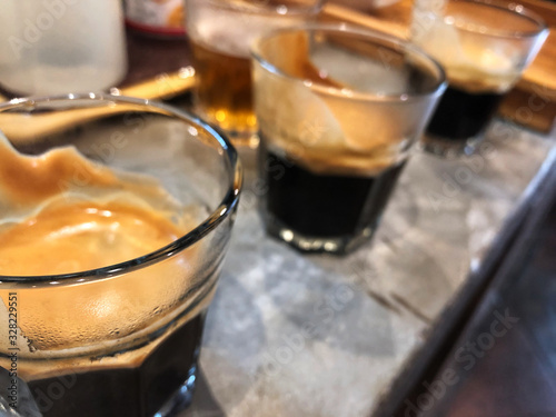 3 perfect espresso shots in glass on the cement counter. Cupping coffee test .