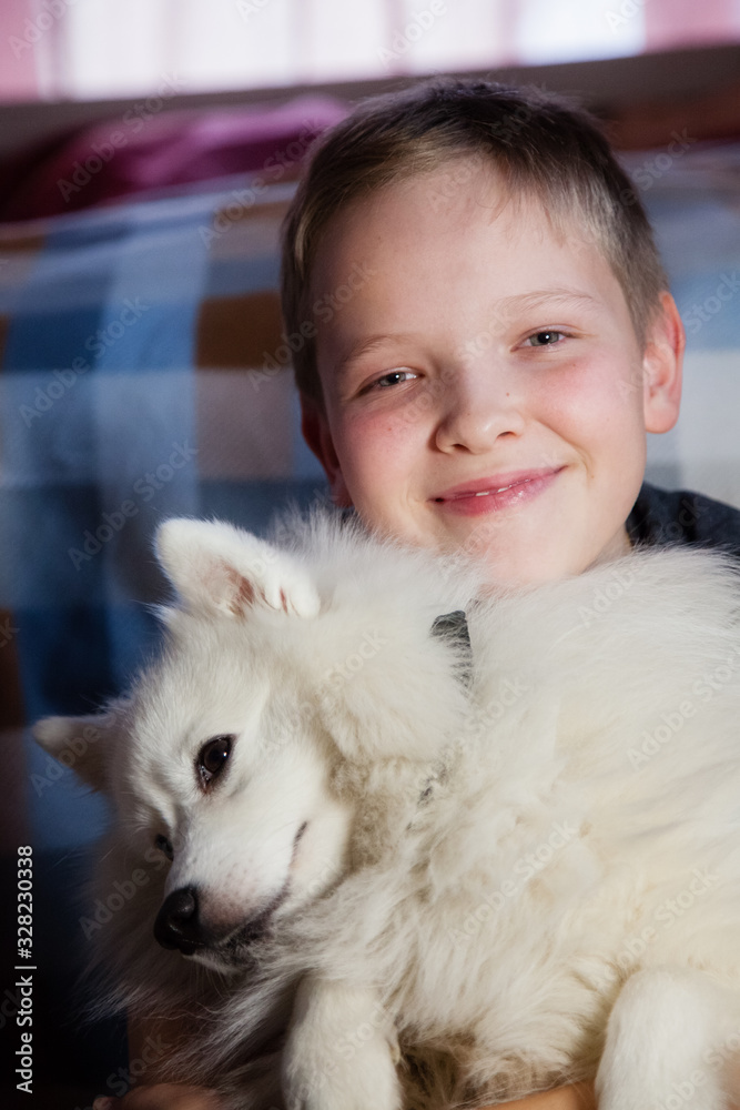 Boy is hugging a white dog with love Boy is hugging a white dog with love