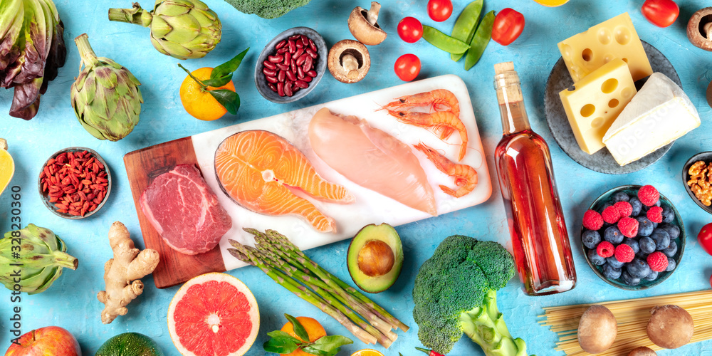 Food, overhead panorama on a blue background. Meat, fish, seafood, poultry, wine, cheese, mushrooms, pasta, nuts, fruits and vegetables, a variety of healthy organic products