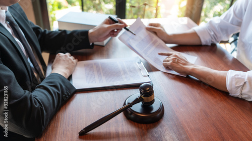 Photography Lawyer working with client discussing contract papers with brass scale about leg