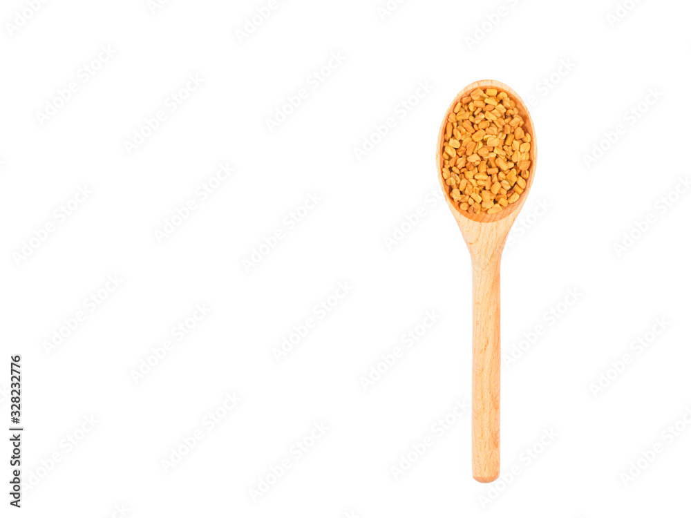 Spice fenugreek in wooden spoon isolated on white Spice fenugreek in wooden spoon isolated on white