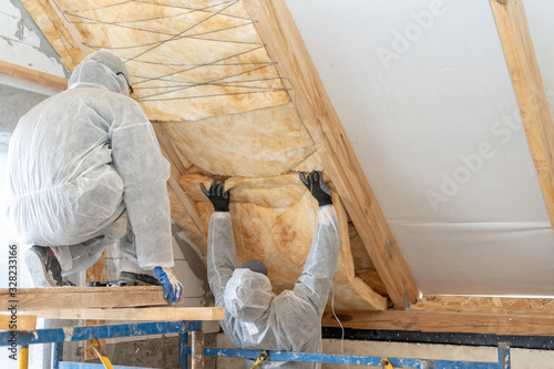 Worker man in overalls working with rockwool insulation material photo