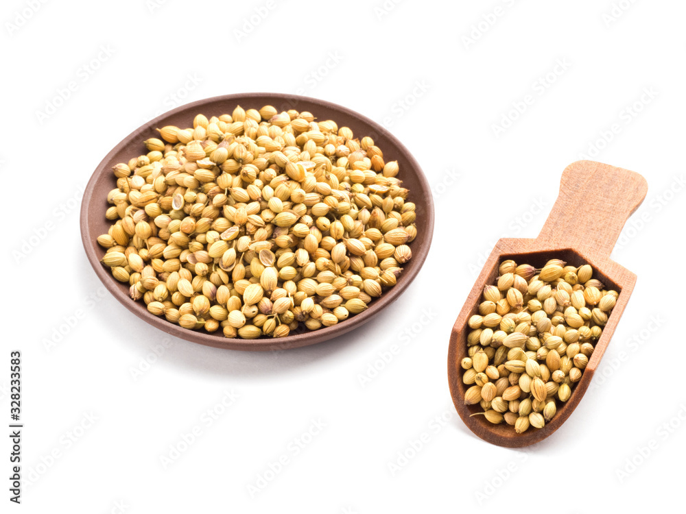 Spice coriander (Coriandrum sativum) seeds in clay plate and wooden scoop isolated on white background. Diet concept