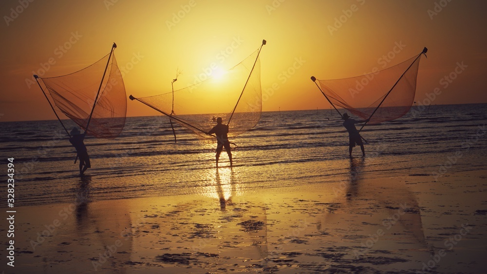 Tan Thanh beach, Go Cong district, Tien Giang province, Vietnam - Feb 2020: Photo of fishing village people using homemade tools to catch fish in sea at sunrise