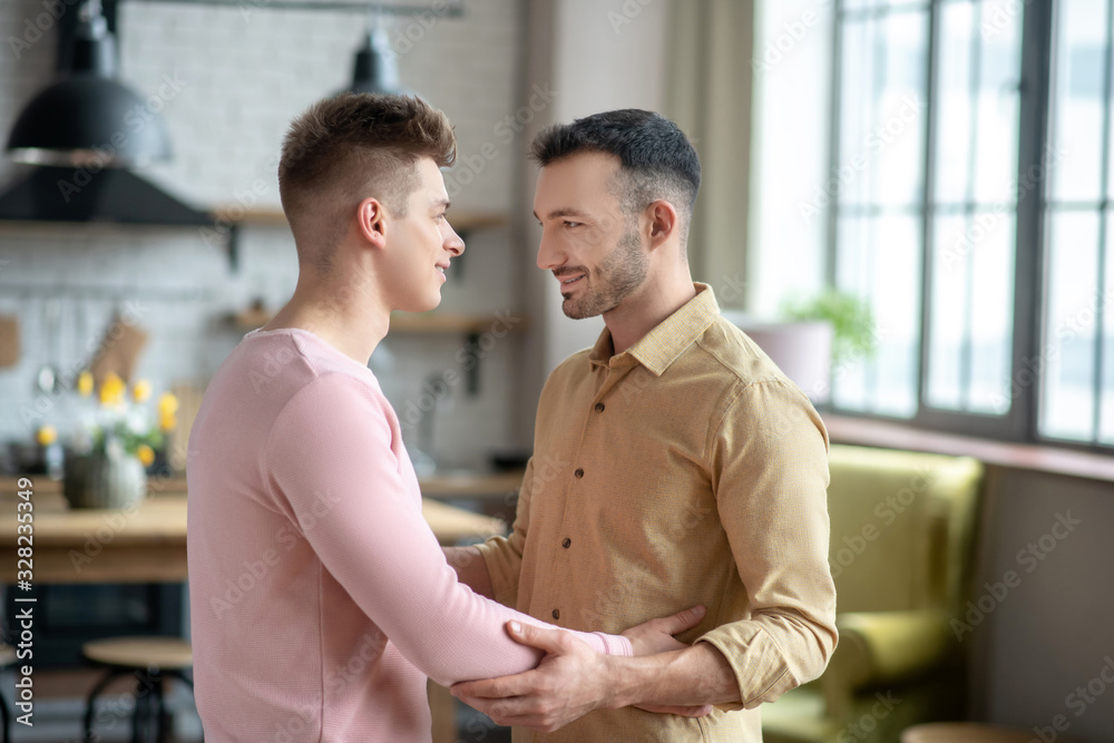 Two young men holding arms and looking at each other Two young men holding arms and looking at each other