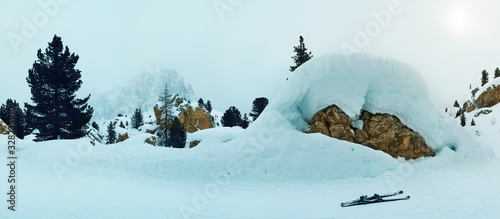 Panoramic evening foggy view of dolomite rocks covered with snow. Dolomite Alps (Sella Ronda). 