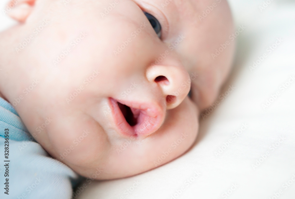 close-up newborn baby boy with blond hair lies on the bed close-up newborn baby boy with blond hair lies on the bed