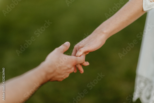 guy holds the hand of a girl with a blurry background © Ilya.K