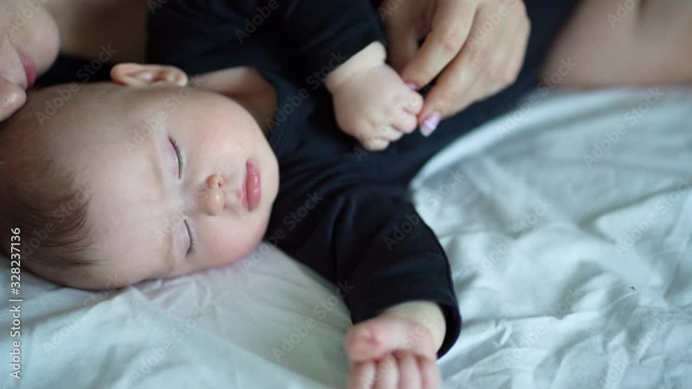 mom and baby in black sleeping together. close-up. mom and baby in black sleeping together. close-up.