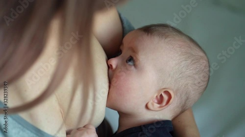 Woman breastfeeding newborn baby. Mother breastfeeding newborn boy. Concept breast feeding. Baby eating mother's milk. Young woman nursing and feeding baby. Concept of lactation infant.