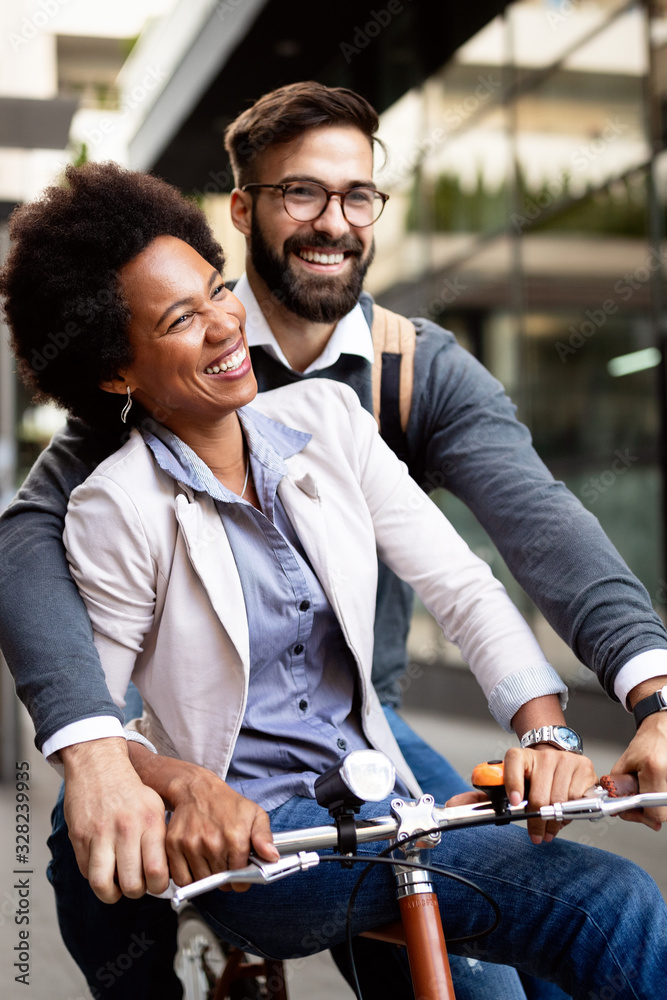 Fototapeta premium Cheerful people going for a bike ride. Happy couple having fun in the city.