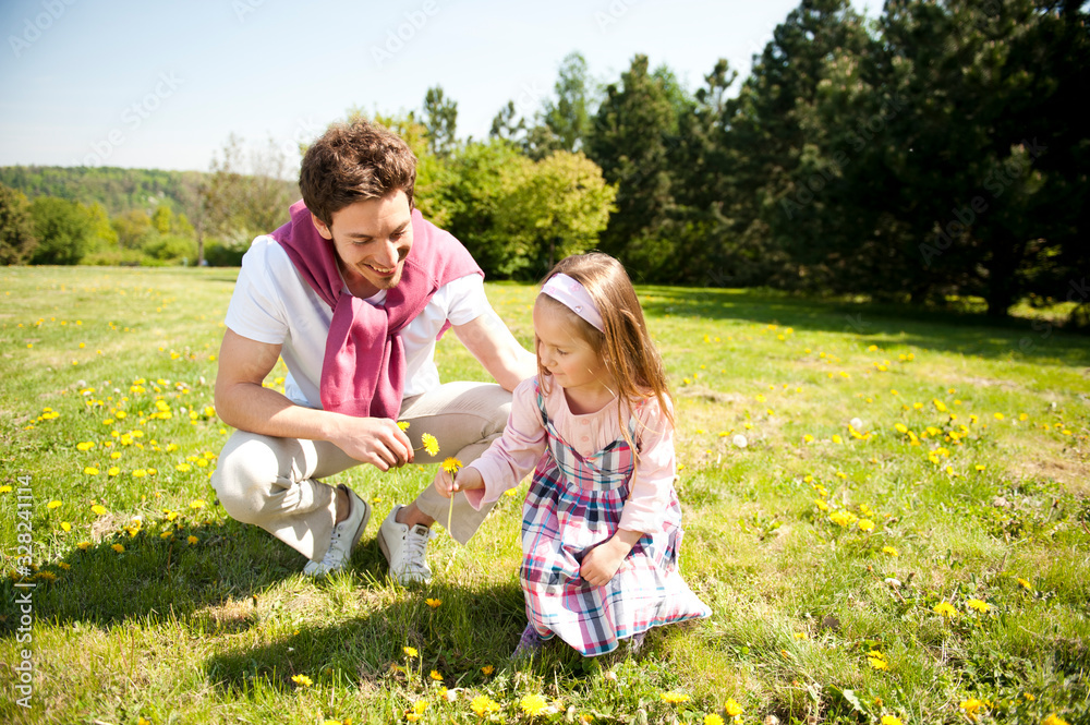 Fototapeta premium Happy family. Father with daughter on a meadow.