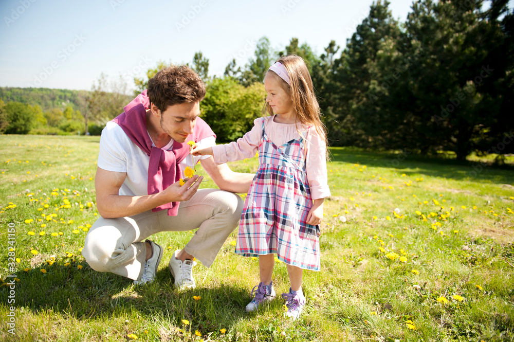 Fototapeta premium Happy family. Father with daughter on a meadow.