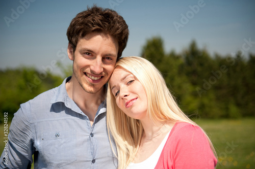 Happy young couple in love on a meadow