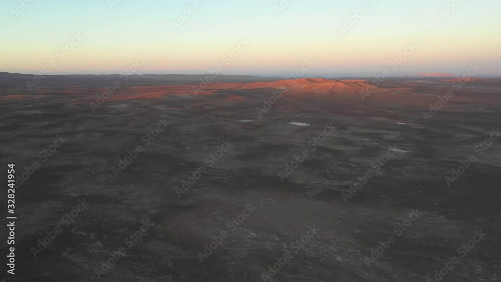 Aerial view of Andes mountains with orange tones from the sunset exploring Atacama Desert vast dry extensions. An awe road trip adventure crossing the infinite sand extensions of this amazing dry land Aerial view of Andes mountains with orange tones from the sunset exploring Atacama Desert vast dry extensions. An awe road trip adventure crossing the infinite sand extensions of this amazing dry land