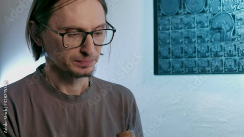 a sick man smokes cannabis against a background MRI image on which his head is. Looped. 4k photo