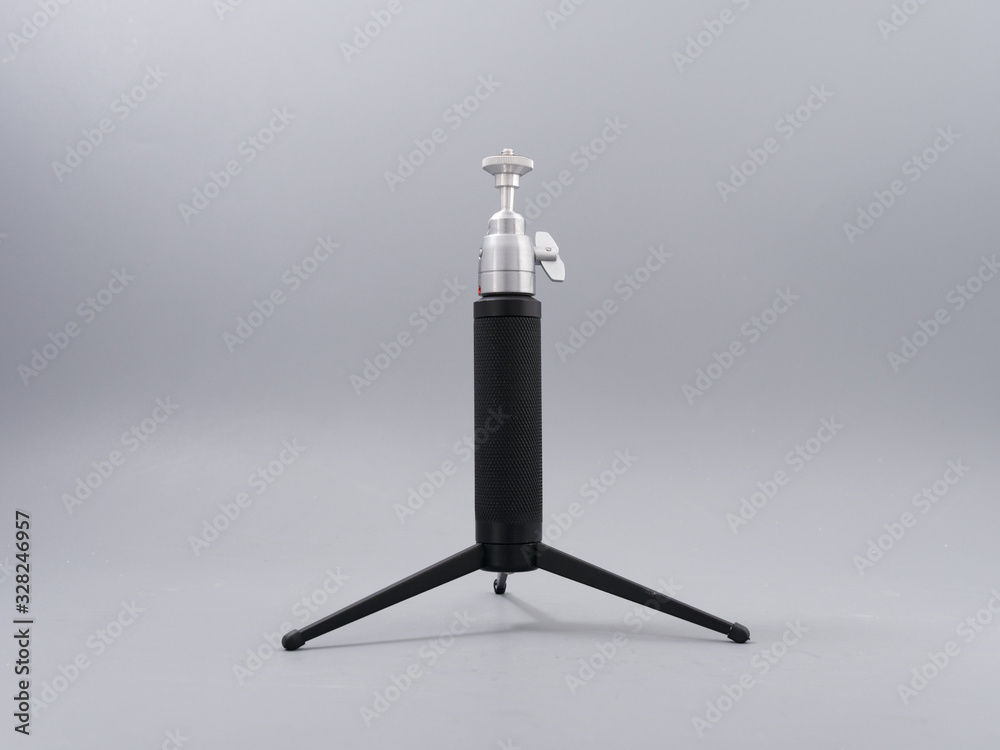 metal mini tripod for the camera on a gray background metal mini tripod for the camera on a gray background