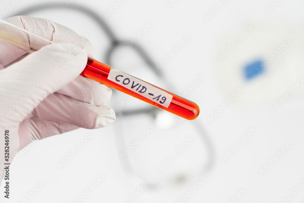 Obraz premium Hand with a laboratory tube with blood sample and the imprint Covid-19