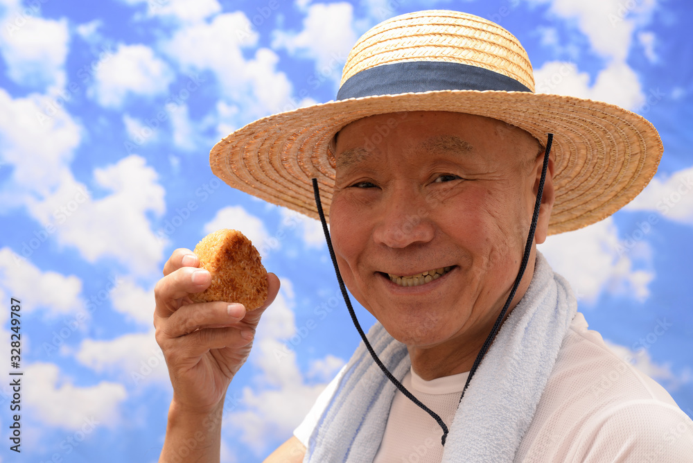 Fototapeta premium 青空でおにぎりを食べるシニア