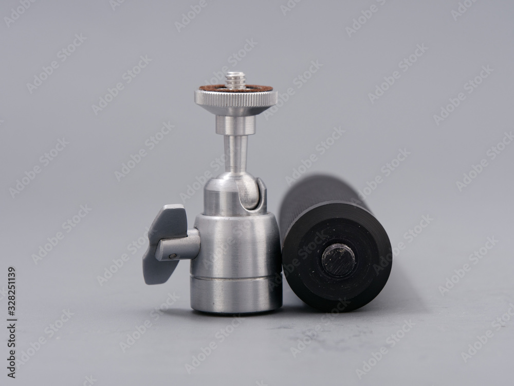 metal mini tripod for the camera on a gray background metal mini tripod for the camera on a gray background