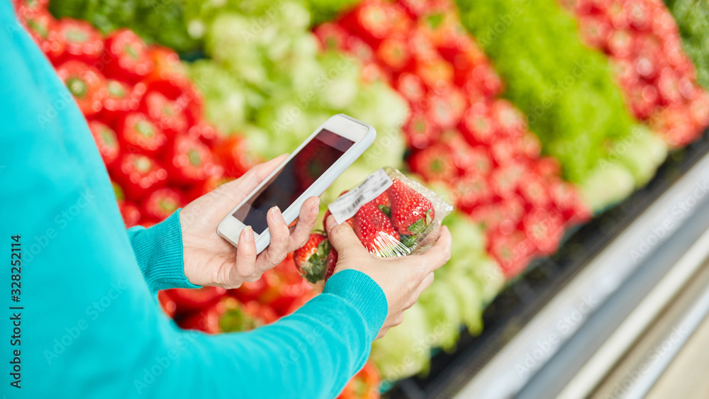Customer uses barcode scanner app in supermarket Stock Photo Adobe Stock