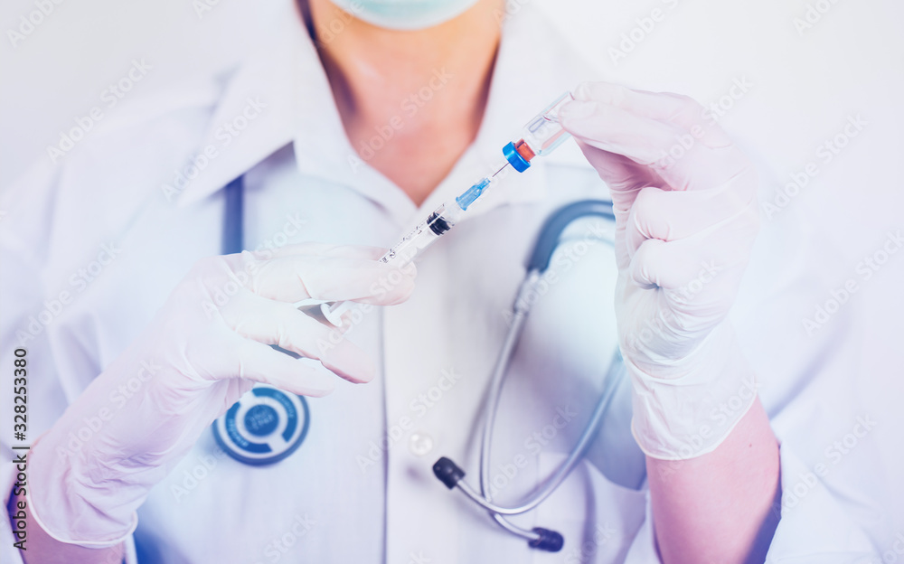 Vaccine bottle and syringe in a doctors hands close-up.  Ncov-19/ Coronavirus concept. 