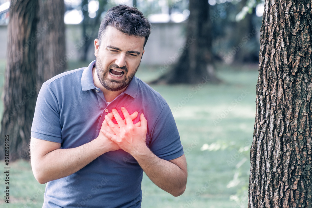Man clutching his chest from sudden pain.Heart attack symptom concept